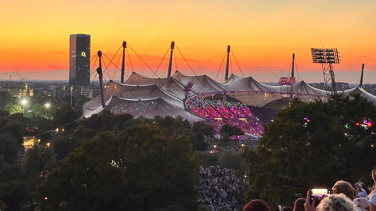 Sonnenuntergang und Konzert - die Aussicht vom Münchner Olympiaberg auf das Olympiastadion und den O2-Tower