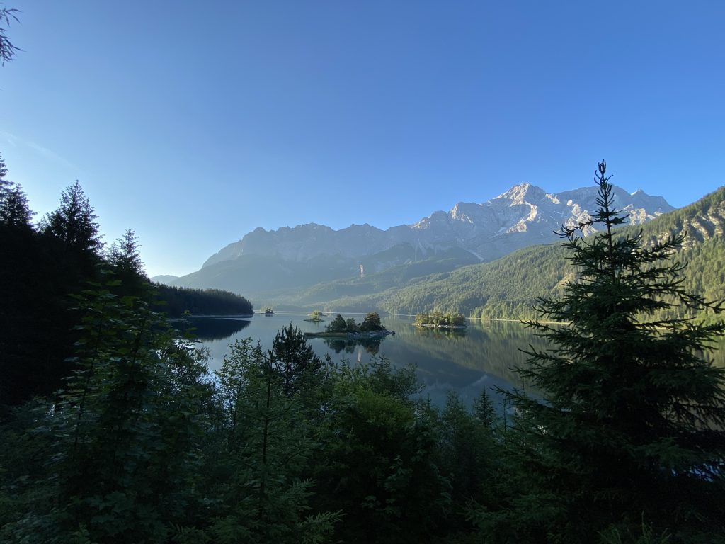 Die Zugspitze spiegelt sich beim Waldspaziergang im Eibsee